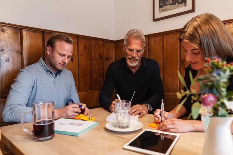 Drei Tagungsteilnehmer am Brainstorming als Gruppenarbeit in einer der beiden Gast-Stuben des Almbad Sillberghaus